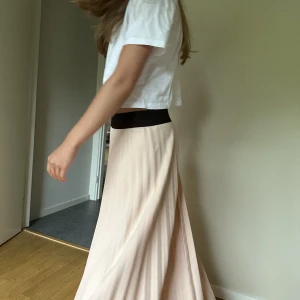 Långkjol  - Rosa långkjol från pomp de lux. Resorbandet är stretchigt så skulle kunna passa även storleken S. Helt oanvänd så är i gott skick! 