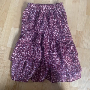 Mörkröd kjol - Medellång kjol med volang, mörkröd med vita prickar. Kjolen är från Shein men har ingen lapp. 