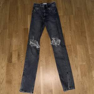 Gråa high waist jeans från Zara med en slits längst ner. De är i bra skick och är i storlek 32.