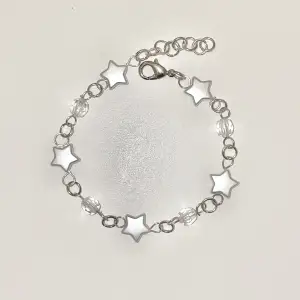 Handgjort armband med vita stjärn pärlor och genomskinliga pärlor. Tryck på köp nu om du vill köpa🥰