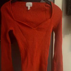 En långärmad tröja med lite större armar ner till. Det är en orange röd färg som är så fin. Den är oanvänd och bara varit i garderoben. Det är storlek M men skulle passa S också även L om man vill ha lite tajtare . Köparen står för frakt❤️