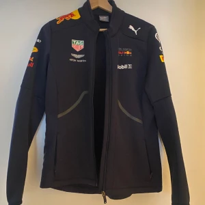 Red bull racing softshelljacka - Perfekt till formel 1 älskaren ✨ Säljer nu min assnygga red bull racing F1 jacka i dam stl M då jag flyttar och ej har plats för alla mina kläder 😞 licenced merch från 2018 kollektionen, så hejar man på både Verstappen och Ricciardo är detta rätt år 🫶🏻