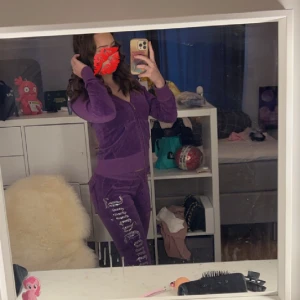 Juicy Couture sett i lila med diamanter och fickor - Den gamla modellen av juicy couture, ett helt sett med fickor på, och även diamanter på ryggen på tröjan samt på benet på byxorna! Skit fin lila färg och perfekt till vintern! Sparsamt andvänd inga skador på den.