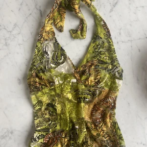 Gullig halterneck  - Halterneck topp med fina detaljer (blommor och fjärilar). Vintage, uppskattas till strl xs !