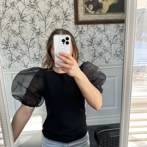 Topp med puffarm  - En svart topp med puffärmar från H&M trend i storlek M