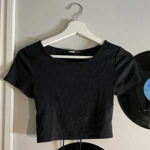 Svart tröja - Tajt svart ribbad tröja med öppen rygg, inte använd. Från Bikbok. Originalpris: 150kr