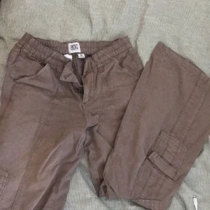 Y2k lågmidjade cargo pants  - Y2k lågmidjade Cargos från Urban outfitters. Säljer då dom inte passar mig. OBS de har ett litet hål (3 bild) men går jätte lätt att sy ihop. Köpt för 700kr 