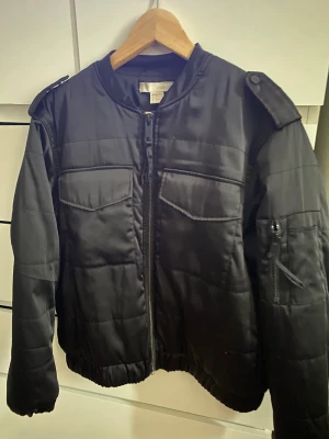 Svart bomberjacka (militär) - En svart bomberjacka med militär fickor. Jackan är otroligt praktisk då den har många fickor. 