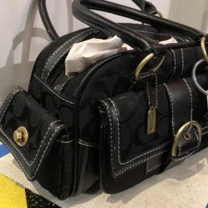 COACH väska - Jättefin väska som inte används. Mycket bra skick förutom lite ytligt slitage vid handtag. Se bild  Längd 30cm Höjd 17cm Bredd 12cm