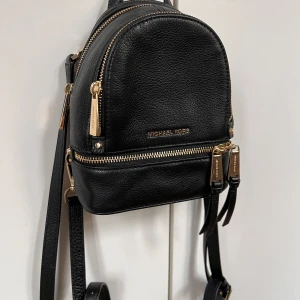 MK väska - Super snygg Michael Kors ryggsäck som man även kan ta bort en rem och använda som crossbody istället.  Guldiga detaljer. Sparsamt använd och smörjer alla mina väskor för att dom ska behålla sin kvalitet.  Hoppas den hittar nytt hem där den får kärlek. 