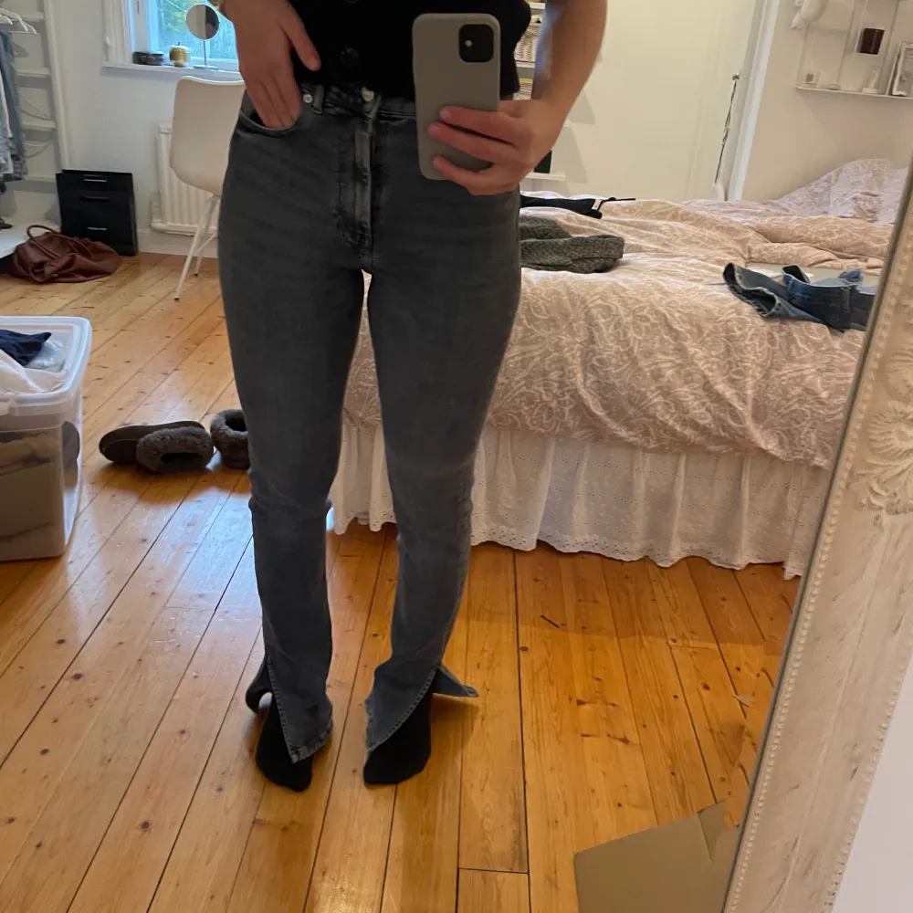 Säljer ett par grå bootcut jeans med slit från zara. Jeansen är i storlek 36 och har lite slitningar längst ner men annars bra skick.. Jeans & Byxor.