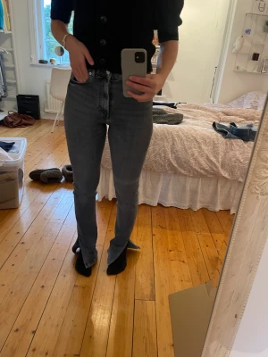 Bootcut jeans grå zara - Säljer ett par grå bootcut jeans med slit från zara. Jeansen är i storlek 36 och har lite slitningar längst ner men annars bra skick.