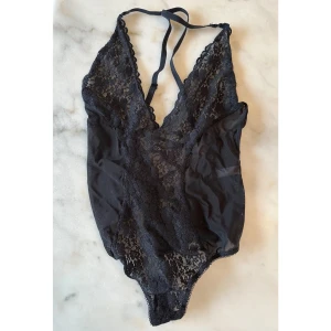 Body i spets och mesh  - Body i mesh och spets. Banden går i kors i bak och ryggen har snörning. Från Nelly Lingerie. Storlek S. 