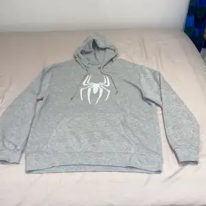 En ljusgrå spiderman Hoodie, har används 2-3 gånger. Den har mjukt material inuti, materialet på hoodien är väldigt bra. 