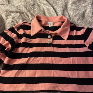 En kort rosa svart tröja med glittrande knappar😍 - Kort tröja för folk som har lite större storlekar men annars jätte snygg 