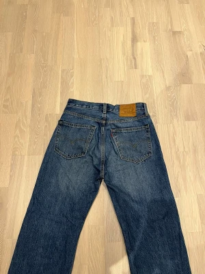 Levis Lot 50's straight - Hej! Jag säljer ett par Levis Lot 50's straight jeans i storlek W30 L32. Dessa  jeans är klassiska och tidlösa med en rak passform. De är i bra skick och har inga skador.