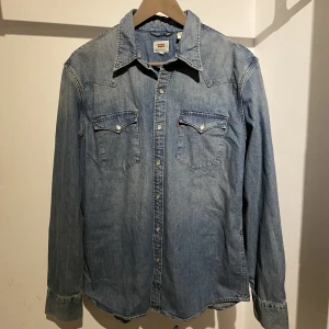 Vintage Levi’s blå skjorta - Säljer en cool vintage Levi’s jeansskjorta i storlek L. Passformen är true to size. Inga defekter som är synliga förutom den tjusiga vintage looken😍 Skriv för mer info eller vid funderingar🤙🏼