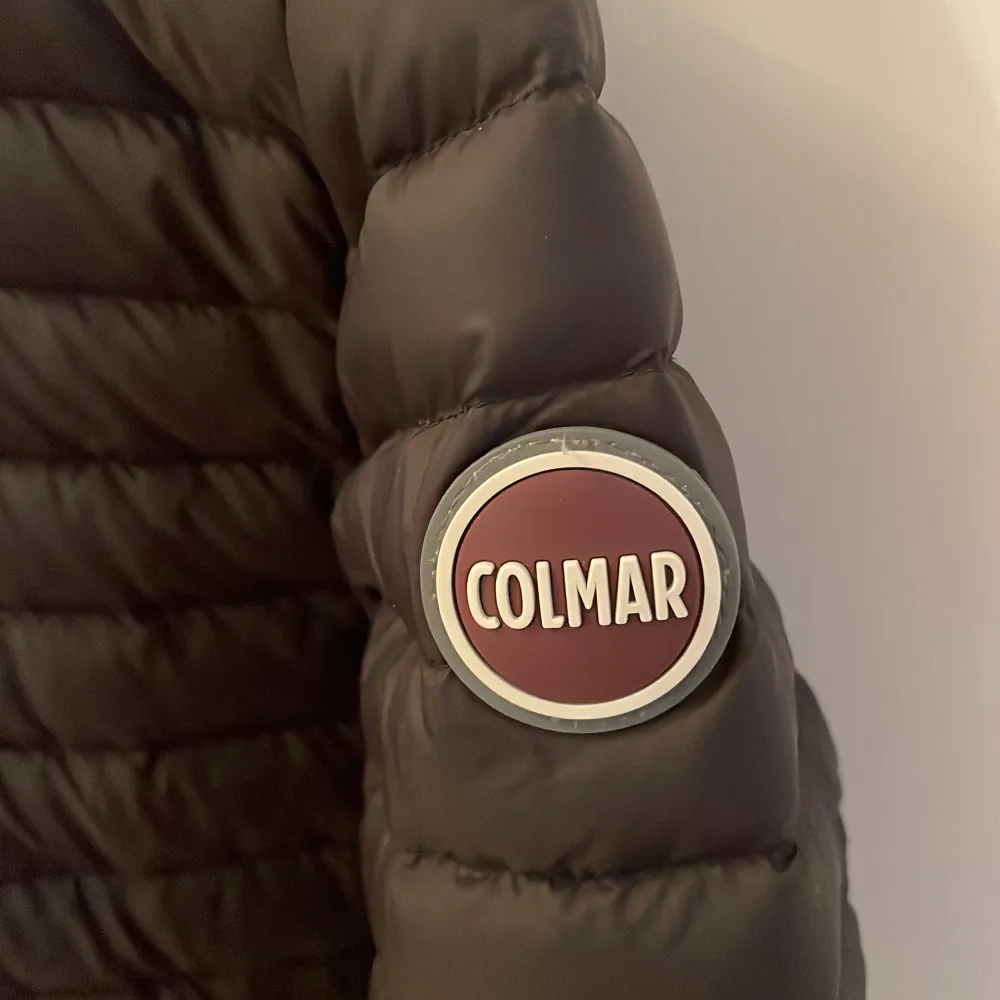 Colmar jacka storlek 14, 166 cm. Lättviktsdunjacka svart, med grå insida och luva. Knappt använd. Väldigt användbar under vår och höst. Superfin!. Jackor.