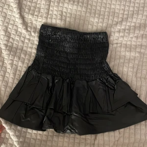 Kjol - Skinn material, väldigt stretchig den går att stretcha ut jättemycket, 