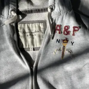 Grå zip hoodie från abercrombie & fitch. Inte helt säker om jag vill sälja men skriv gärna hur mycket ni skulle vilja betala. Dragkjedjan är tyvärr sönder men funkar relativt bra ändå. Står M på lappen men passar som s💗