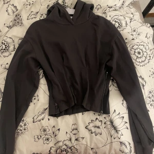 Grå hoodie  - En croppad grå hoodie med kedjor vid sidorna. Köpt från asos från Urban Revivo 