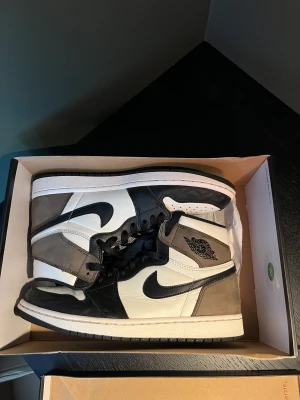 Jordan 1 retro high dark mocha - Skick 8/10, bortsett från att hälen har vikt sig lite och svaga vattenmärken på mockan är skorna i väldigt bra skick.   Kvitto finns ej.   Tveka inte på att be om fler bilder eller mer info! Kan mötas upp i Gbg.  Priset kan diskuteras 