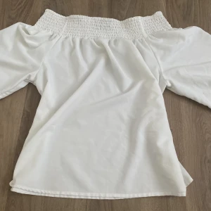 Blus - Vit blus från Zara som fungerar med och off shoulder! Har volanger vid änden av ärmarna och är stretchig både där och vid axlarna, som man kan se på bilden. Knappt använd<3 Ordpris förmodligen 299