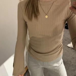 Beige längärmad  - En beige långärmad tröja. Med slits på sidan av ärmen. I storlek medium men skulle säga att den passar till en small också. 