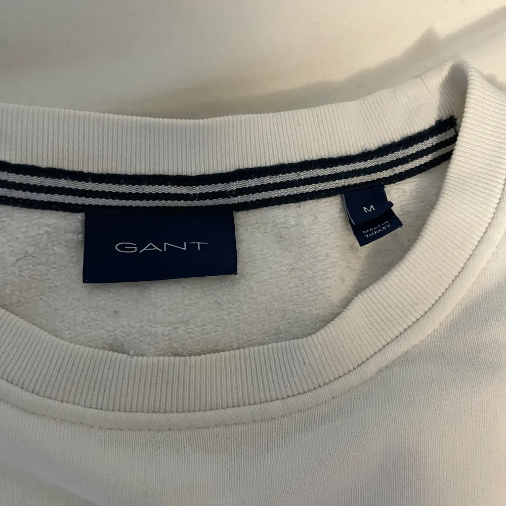 Gant tröja vit i använt skick, har några fläckar men vet ej om de går bort i vanlig tvätt kanske med Vanish. Hittade i garderoben, storlek M. Tröjor & Koftor.