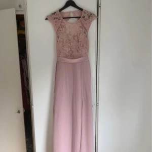 Lång klänning  - Lång babyrosa klänning med slits och öppen rygg från Nelly. Använd en gång. Finns i Malmö. Storlek 34. 