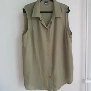 Grön, ärmlös skjorta i ett skönt meshigt material. Är inte genomskinlig. Har använts ett fåtal gånger och är i ett fräscht skick.