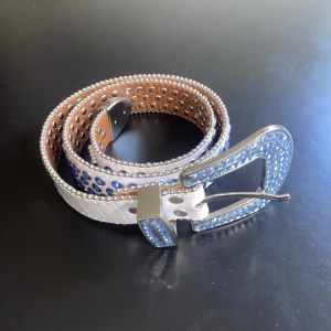 Bb simon bälte rep - B.B. Simon bälte blåa kristaller vitt läder. Rep. 115cm