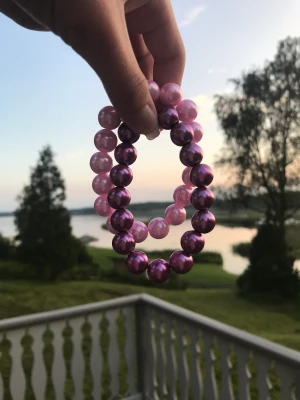 Två vackra pärlarmband. - Säljer dessa två vackra pärlarmband. Ett rosa och ett lila. Säljer det rosa i denna annons men har det lila på min profil. Kontakta gärna vid frågor.  Har också andra smycken på min profil.