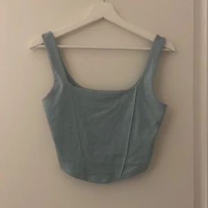 Topp med detaljer - En topp som är längre framtill och kortare baktill 