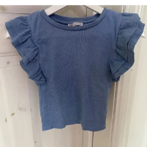 Blå topp - Blå topp med volanger från zara! Storlek M men passar mig som har S, använd en gång