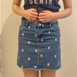 Jeanskjol - Jeanskjol med rosa hjärtan. Den har varit min allra favoritkjol då den är unik och så söt. Bra skick. Kontakta vid frågor!