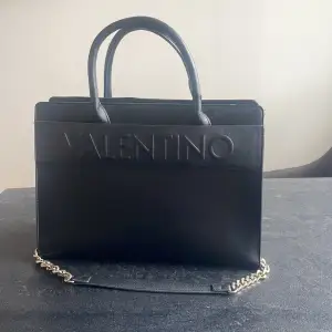 Otroligt fin valentino väska! Rymlig, får plats med en dator osv. Kommer med två axelremmar, en guldkedja samt svart läder. Köpt för 1300kr, mitt pris 500kr. 