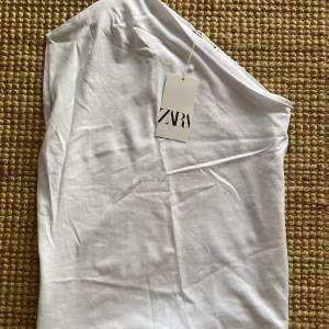 Superfin one shoulder topp från Zara i t-shirt material. Nypris 179, oanvänd. 100% bomull.