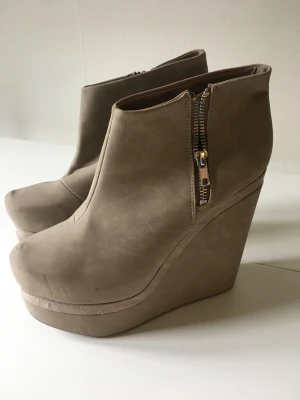 Beige platå/kilklacksko - Beige platå/kilklacksko. Blixtlås på insidan. Nyskick, aldrig använda. 