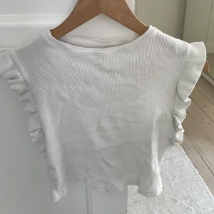 Topp med volang vid ermen - Jättefin! Dock ser jag lite små fläckar så jag ska tvätta de o se om det går bort!