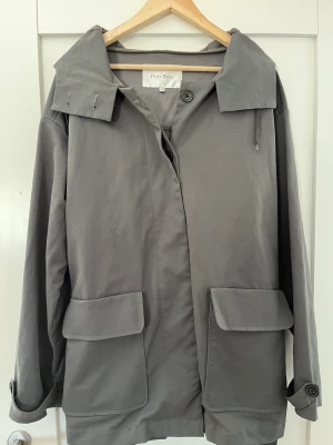 Höstjacka Part Two strl 40 - Superfin, antracitgrå ofodrad kappa/jacka från Part Two (modell Cianti) som kort efter kör blev för stor för mig och är därmed princip oanvänd. Strl 40 men rymlig. Långa, härliga armar. Justeras med bälte samt knappar vid ärmslut. 