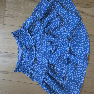 Somrig volang kjol - Somrig volang kjol i blå färg med vita blommor!💓Perfekt till skolavslutnin eller allmänt, super skön och hör av dig om du har några funderingar💓Svarar alltid!!💓 Berädd på att sänka priset😊