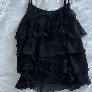 Volang topp med strass - Volang topp med strass detaljer. Jättefin men kommer inte till användning. Går att ställa in axelbanden. Inga fläckar eller hål.