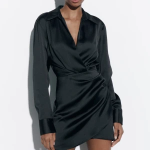 Festlklänning  - Svart miniklänning i satin från Zara Använd 1 gång  Dragkedja i sidan och draperad vid höfterna Passar både M och S  Perfekt till fest eller när som helst! En tråd på ryggen har löpt (se bild), syns inte när klänningen är på Nypris 400