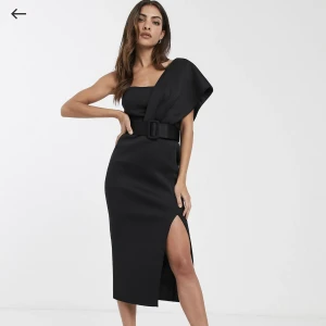 Svart klänning - En tight, svart och smickrande cocktailklänning från ASOS. Den är gjord av ett tjockt plyester tyg som faller snyggt längs kroppen. Använd en gång, men har en liten defekt på slitsen (se bild) Storlek: 38 Nypris: 650