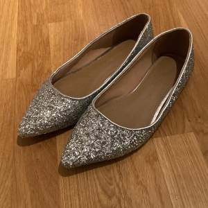 Silver glittriga ”ballerina” skor som aldrig är använda.  De är UK 5 i storlek vilket motsvarar 38. 