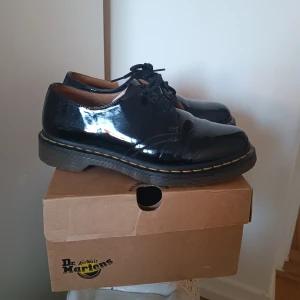 Låga Dr Martens 1461  - Dr Martens 1461 (3 eye shoe patent kamper) i storlek 40. I skinn med lackerad yta. Använda ett fåtal gånger. Nypris 1800.