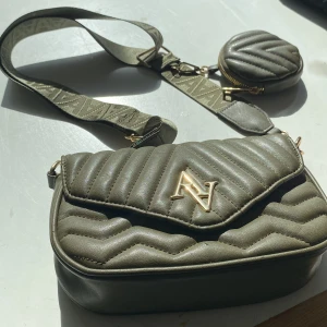 AA väska - Säljer min väska som jag köpte från New Yorker med en mindre väska på bandet (både bandet och mini-väskan är avtagbar), nypris ca. 250kr säljer för 90kr. Använd ungefär 2 gånger+inga defekter av användning.
