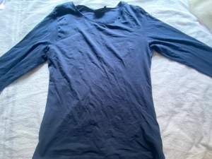 En blå långärmad tröja som är storlek M men som sitter lite lösare på mig som brukar ha storlek M i tröjor! 