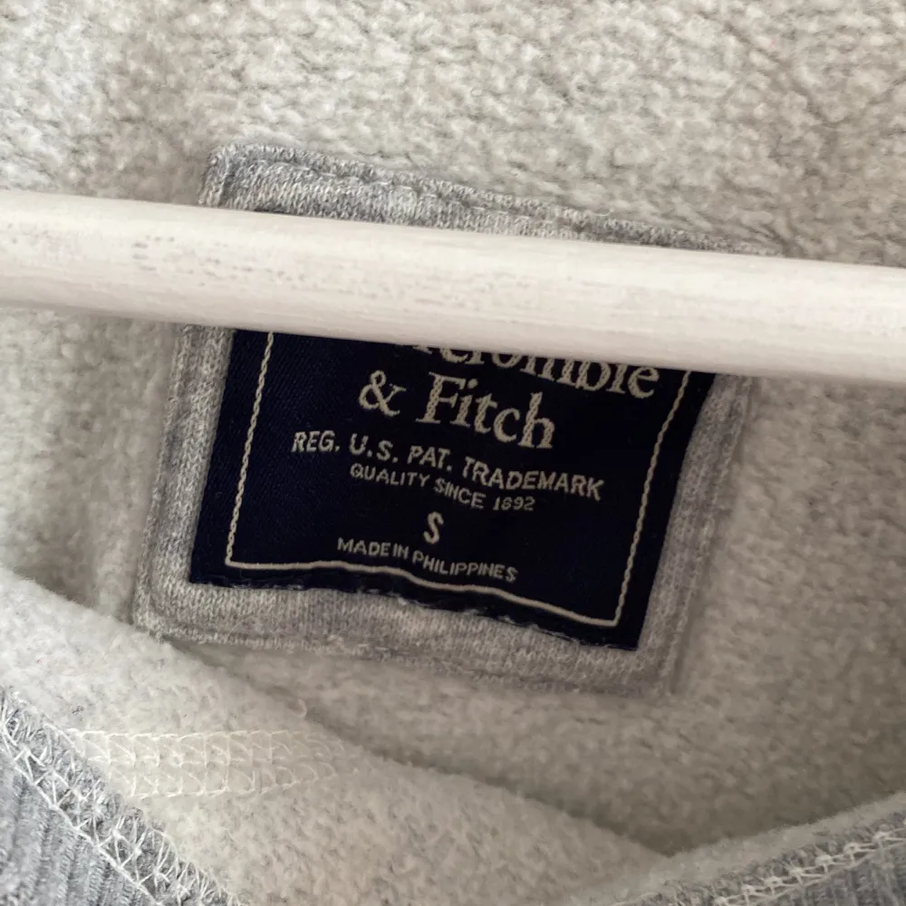 Grå sweatshirttopp från Abercrombie & Fitch. Trycket/broderingen på framsidan är lite missfärgad (se bild 2) så den är äldre, därav det billiga priset💕✨. Toppar.